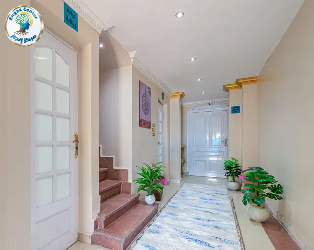 ممر الغرف بإضاءة هادئة وسجاد أزرق