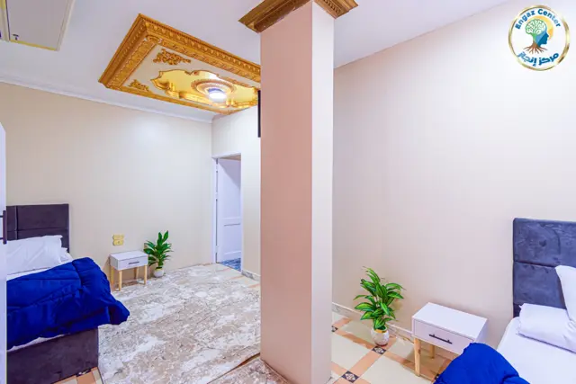 غرفة بسريرين وسقف مزخرف ذهبي